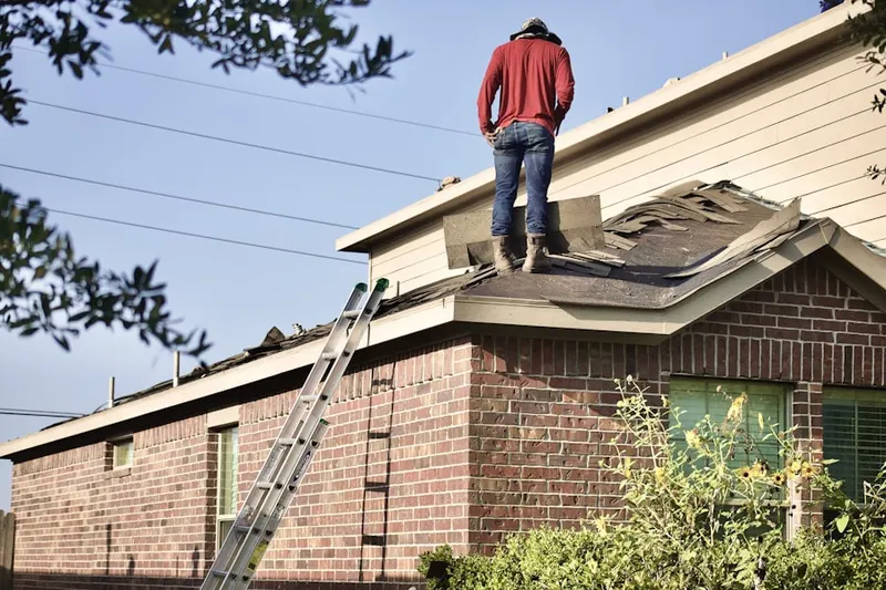 Professional roofer working on a residential roof in Fort Lewis